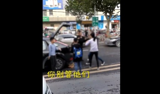 ▲▼河南鄭州日前有兩輛轎車發生擦撞，車主在街頭鬥毆，一名車主的孩子在旁邊勸架，另一名車主的孩子則淡定觀戰。（圖／翻攝《梨視頻》）