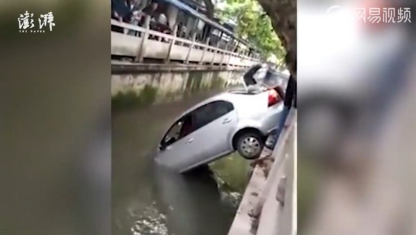 ▲▼江蘇女司機駕車衝進河，車身呈45度懸掛岸邊。（圖／翻攝自澎湃新聞）