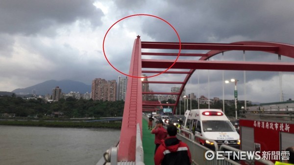 ▲快訊／紅衣男爬關渡大橋　離地面20公尺高嚇壞路人。（圖／記者林煒傑翻攝）