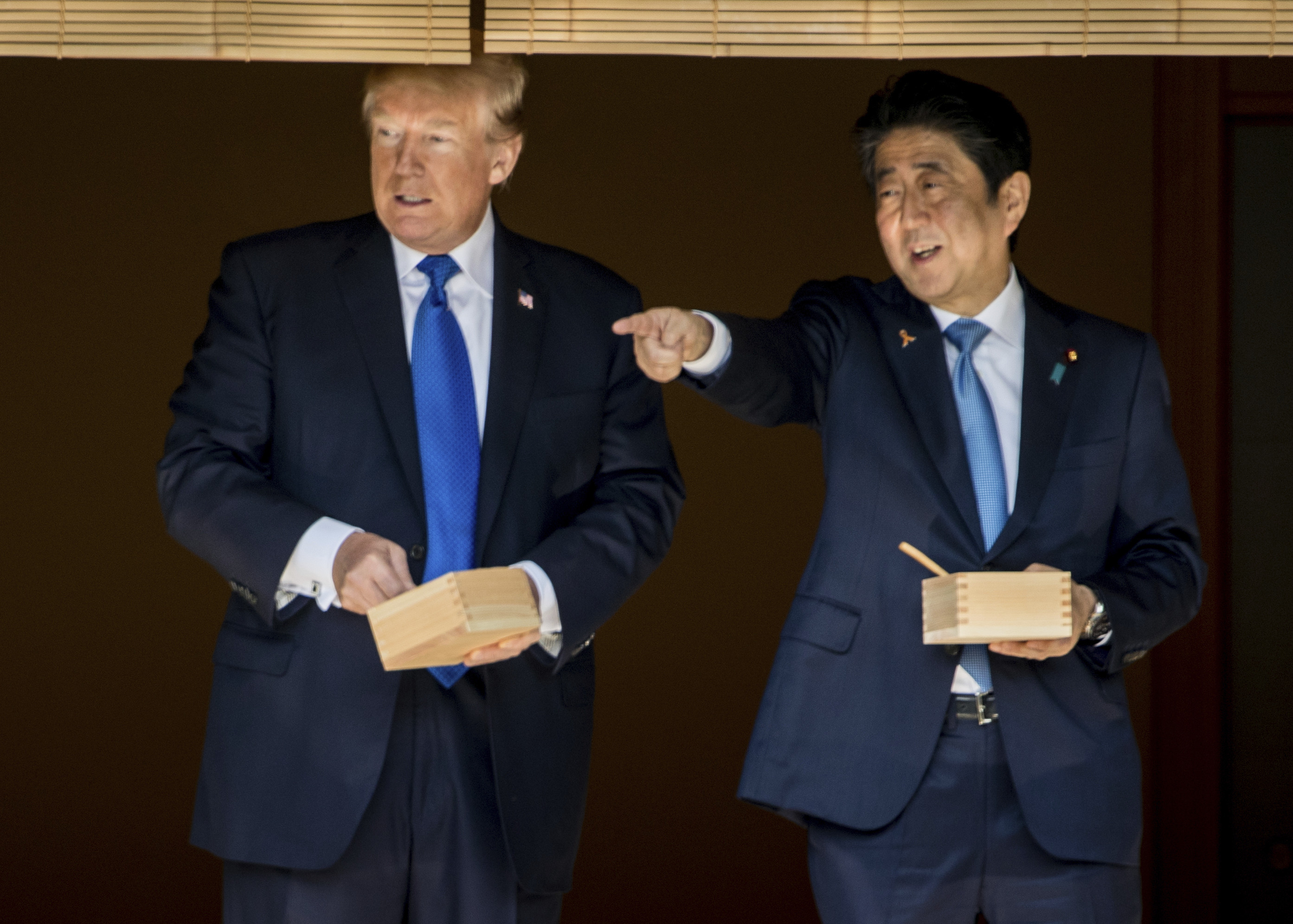 ▲美國總統川普（Donald Trump）與日本首相安倍晉三一同餵食錦鯉。（圖／達志影像／美聯社）