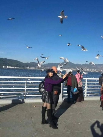 ▲▼一對父女在雲南昆明海埂大壩抓海鷗拍照。（圖／翻攝自《封面新聞》）
