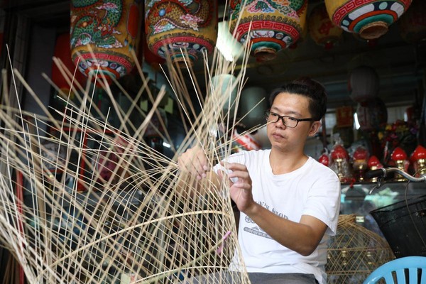 春秋美術社的第二代，正在進行燈籠編織工作。