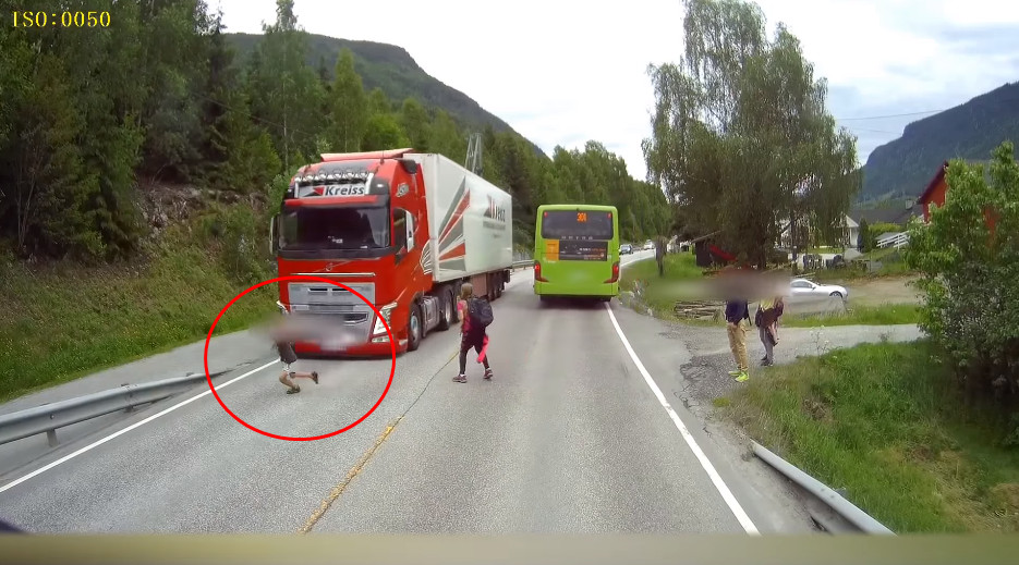 ▲挪威一名孩童未察看交通路況，竟直接奔跑穿越馬路，差點被貨櫃車撞到。（圖／翻攝自YouTube）