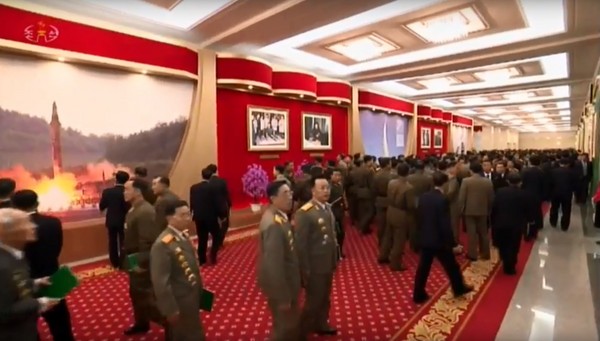 ▲▼會議大廳的牆上掛滿北韓展示軍力照片。（圖／翻攝自北韓《中央電視台》畫面）