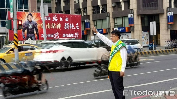 ▲台南市長參選人顏純左，站在「台南站神」看板的前面拜票，經過的民眾都比讚。（圖／顏純左提供）