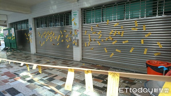 ▲民進黨市黨部門口鐵門上貼滿黃色符令。（圖／記者林悅翻攝）