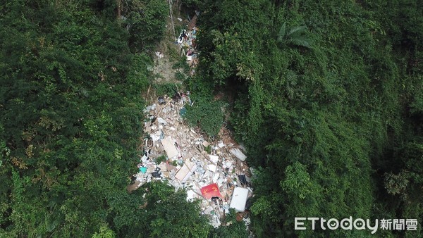 花蓮吉安鄉楓林步道旁林地遭人違法丟棄大量廢棄物，經由空拍評估現場丟棄廢棄物高達十噸，遠從4公里外的山腳下就看得到垃圾瀑布。（圖／保七總隊提供）