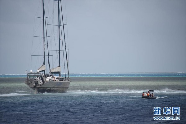 巴西籍動力帆船在南沙三角礁淺灘擱淺，中國海警船施放快艇，成功救助3名船員。（圖／翻攝自新華網）