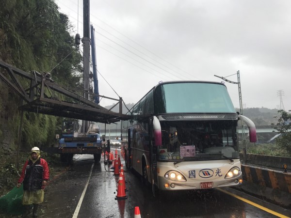 ▲一輛國光客運6日經基隆市暖暖區源遠路102巷時，遭吊車吊掛的鐵架撞破玻璃。（圖／民眾提供）