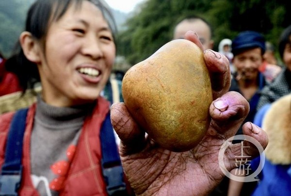 ▲▼48歲的居民李雲瓊撿到一塊玉，笑得合不攏嘴。（圖／重慶晨報）