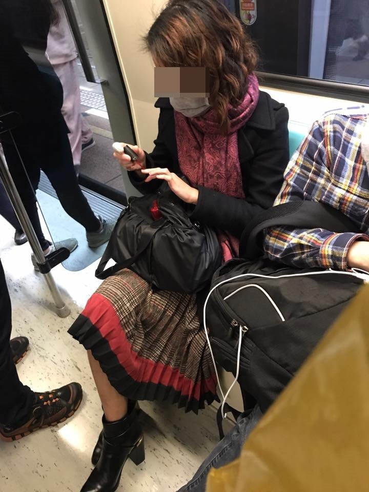 女在捷運車廂擦指甲油。（圖／翻攝「爆料公社」）
