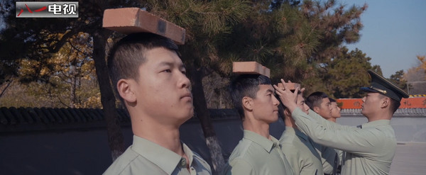 《中國軍網》揭密釣魚台國賓館警衛部隊訓練畫面，為要求動作標準，在手的縫隙中夾著撲克牌。此外還需經過頭頂磚塊、背插木棍、頸別鋼針等嚴格考驗。（圖／翻攝自八一電視）