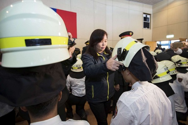 ▲新竹市副市長沈慧虹為新生戴上消防帽。