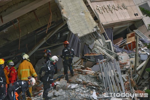 206花蓮地震，搜救隊員從倒塌的雲門翠堤大樓瓦礫殘堆中移出罹難者遺體。（圖／記者張一中攝）