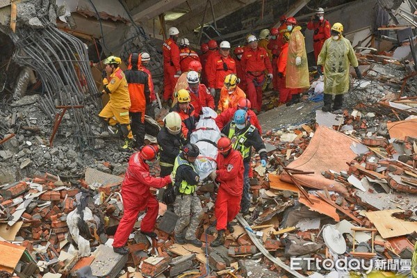 206花蓮地震，搜救隊員從倒塌的雲門翠堤大樓瓦礫殘堆中移出罹難者遺體。（圖／記者張一中攝）