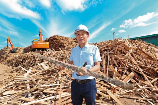 堆積如山的廢棄橡膠木，對謝榮輝來說像是源源不絕的寶藏，可加工製成塑合板。