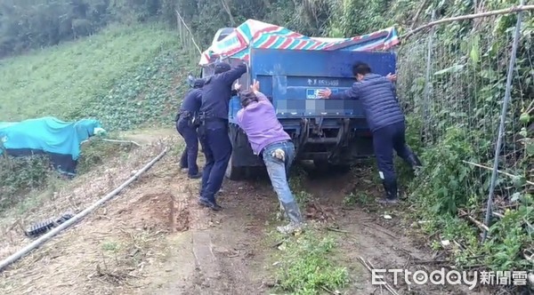 吳姓民眾等6人所駕駛的貨車在西寶山海拔1000公尺處，因產業道路泥寧又溼滑，導致車輛陷入水溝動彈不得，警方使用四輪傳動車上的粗繩拉車，後方人員持續往前推，費了九牛二虎之力才將該車及人員順利救出。（圖／鳳林分局提供）