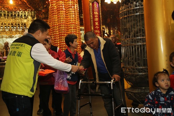 ▲台南市議員參選人黃俊策等人發放100元「媽祖紅包」給參與信眾。（圖／記者林悅攝） 