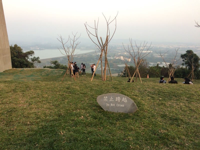 ▲台灣人遊「崗山之眼」無視警告標語，直接走進草皮拍照。（圖／翻攝自Dcard）