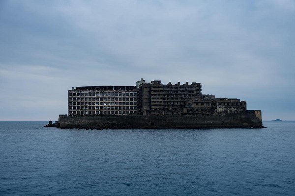 已經關島多年的軍艦島，島上只餘頹圮空屋，依稀可見昔日榮華。