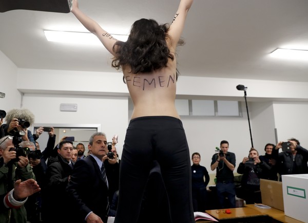 ▲▼前義大利部長會議主席貝魯斯柯尼（Silvio Berlusconi）要投票時，女權抗爭團體「費曼」（FEMEN）的成員突然襲擊。（圖／達志影像／美聯社）