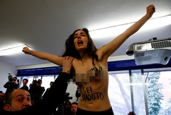 ▲▼前義大利部長會議主席貝魯斯柯尼（Silvio Berlusconi）要投票時，女權抗爭團體「費曼」（FEMEN）的成員突然襲擊。（圖／路透社）