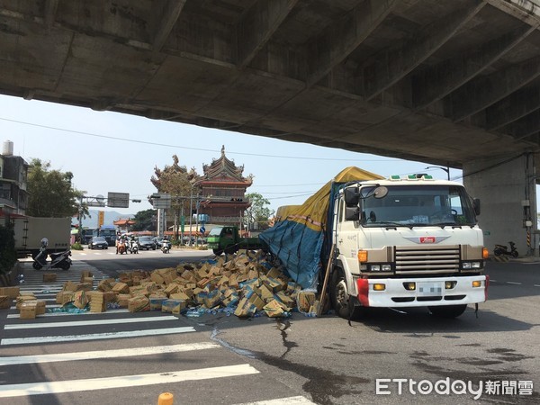 ▲▼八里一輛貨車過彎時貨物翻落，數十箱礦泉水散落一地。（圖／記者林煒傑翻攝）