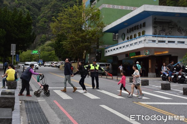 清明節連假第2日天祥出現大批人車潮，遊客想要穿越斑馬線通往兩側都難找到機會，員警只得充當紅綠燈擋下車輛，才能讓行人快速通過。（圖／新城警分局提供）