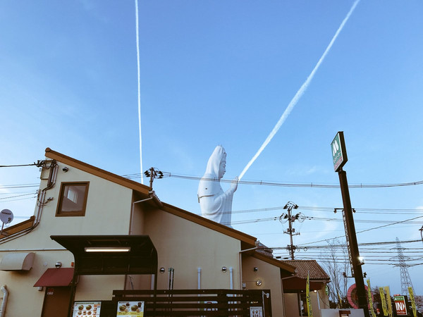 網友「こたき@趣味アカ」在推特上發了一組照片，從中可以看到日本仙台高12層樓的大觀音「從手中發射出光線」，就像是顯靈一般；但其實那只是飛機開過，在空中留下的痕跡，很巧的角度高好對到，所以才像是「開大絕的必殺技」。（圖／翻攝自こたき@趣味アカ）