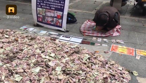▲▼ 湖南懷化一名中年男子於街頭行乞時，放置堆成小山的鈔票，引人注目。（圖／翻攝自梨視頻）