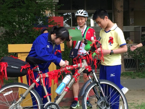 ▲▼學童為光哥的腳踏車繫上象徵關懷愛滋的紅絲帶，以實際行動表達支持。（圖／露德協會提供）
