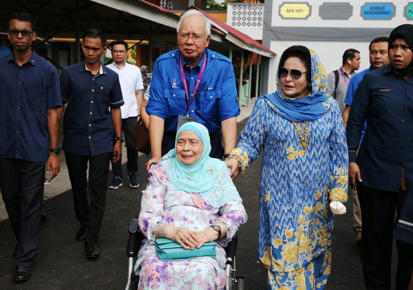 ▲▼馬來西亞前總理納吉（Najib bin Abdul Razak）推著母親哈拉（Rahah Noah），和妻子羅斯瑪（Rosmah Mansor）一起前往投票所投票。（圖／路透社）