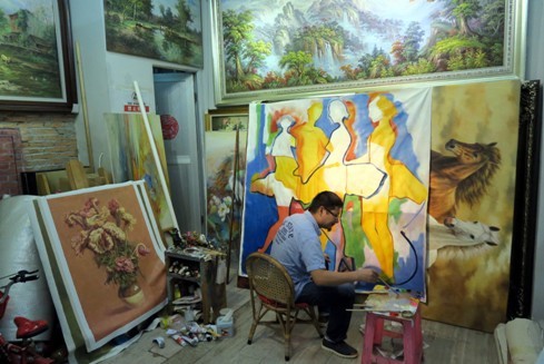 ▲▼深圳大芬村一家畫廊的主人在畫油畫。(圖／新華社照片)