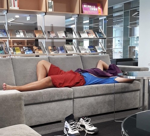 ▲▼男躺在清大圖書館沙發呼呼大睡。（圖／翻攝靠北清大）