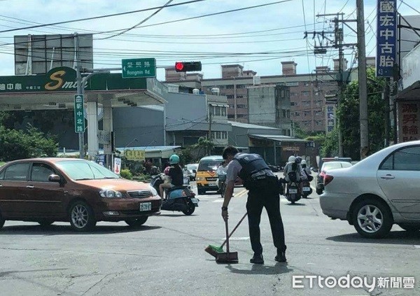 ▲員警在十字路口掃玻璃。（圖／中壢警分局提供）