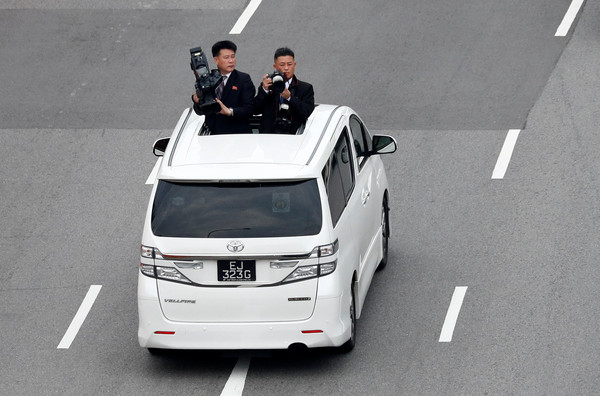 ▲▼川金會／北韓領導人金正恩搭乘座車前往聖淘沙嘉佩樂酒店前，北韓記者一路狂拍照。（圖／路透社）