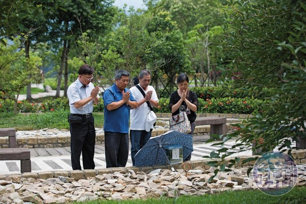 善願創辦人郭志祥（左一）與志工王福祿（左二）陪同家屬送往生者樹葬，共同祝禱死者離苦得樂。