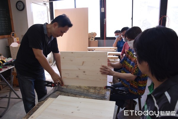 花蓮市長魏嘉賢勉勵原住民傢俱木工研習學員，在老師指導下也親自下場學習木板卡榫結合的技巧。（圖／花蓮市公所提供）
