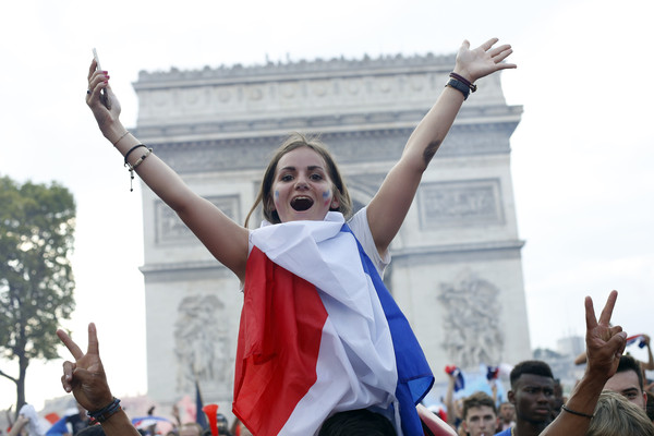 ▲法國獲得世足賽冠軍後，一名女球迷在凱旋門前展開雙臂慶祝勝利。(圖／達志影像／美聯社)