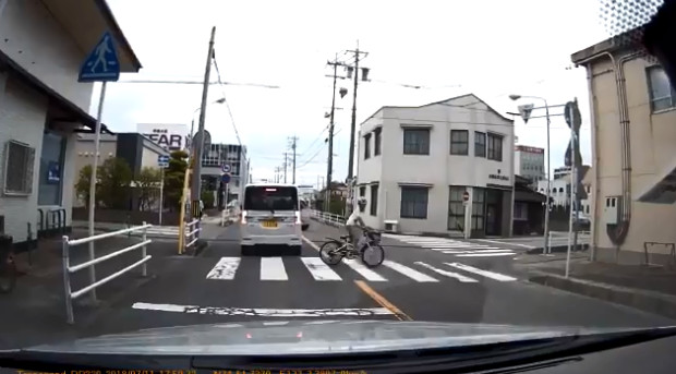 ▲日本駕駛一個「假動作」幫助騎單車的孩童過馬路。（圖／翻攝自tkuma_t_c推特影片）