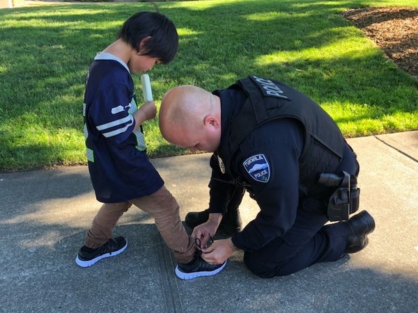 ▲警察跪地幫小男童綁鞋帶，畫面感動千人。（圖／Tukwila Police Department臉書）