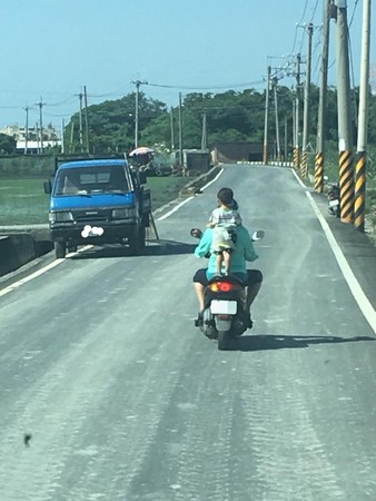 小朋友站機車後座只靠背帶支撐。（圖／翻攝自爆料公社）