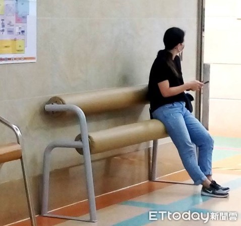 ▲台南市成大醫院門診大樓電梯前，出現由支架與2根1高1低、包著沙發皮的海棉橫槓組成的「歇腳椅」，民眾可坐坐看。（圖／成醫提供）