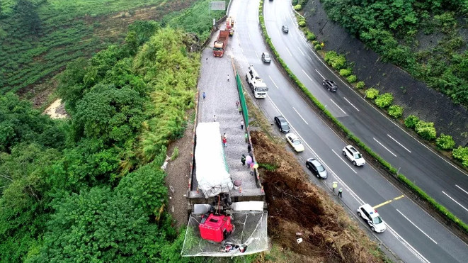 ▲▼貨車失控衝破懸崖擋牆！　駕駛噴飛「落網」掛空中。（圖／翻攝自環球時報）