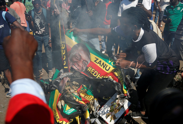 ▲▼辛巴威大選，抗議者焚燒總統姆南加瓦（Emmerson Mnangagwa）的布條。（圖／路透）。