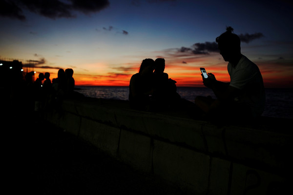 ▲▼古巴人在哈瓦那海邊的Wi-Fi熱點上網，和親友聊天。（圖／路透）