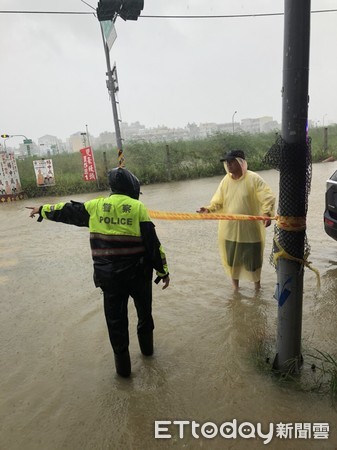 ▲台南市區豪雨淹水，警方冒雨封鎖道路管制交通。（圖／記者林悅翻攝，下同）