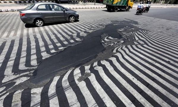  印度新德里熱浪導致路面鋪設的柏油融化。（網路截圖/Guardian）