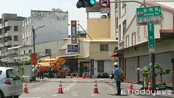 ▲台南市南區利南街驚傳道路塌陷吞60噸重大吊車事件，一輛60噸大吊車，從新興路倒車要進利南街工地時，右側車體突然傾斜陷入道路塌陷的坑洞中，現場鎖管制。（圖／記者林悅翻攝，下同）