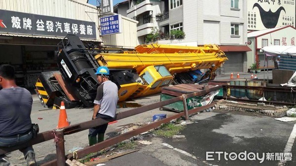 ▲台南市南區利南街驚傳道路塌陷吞60噸重大吊車事件，一輛60噸大吊車，從新興路倒車要進利南街工地時，右側車體突然傾斜陷入道路塌陷的坑洞中，現場鎖管制。（圖／記者林悅翻攝，下同）